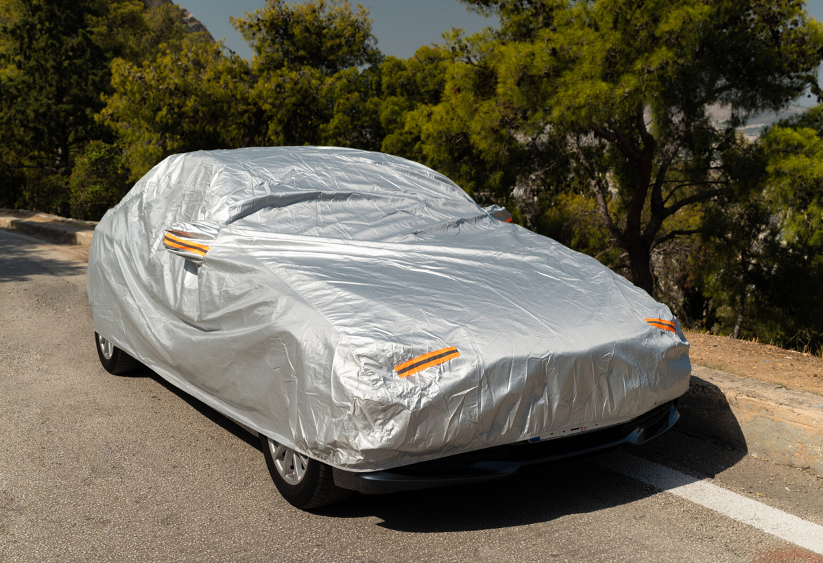 Απεικονίζεται ένα αμάξι καλυμμένο από την κουκούλα προστασίας.